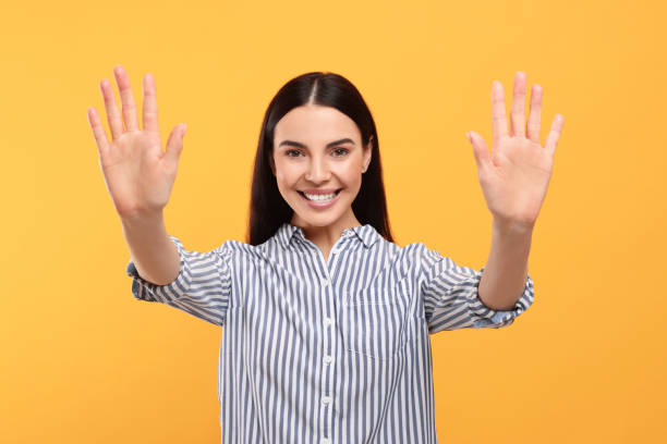 istock Happy woman giving high five with both hands on orange background 1819013898
