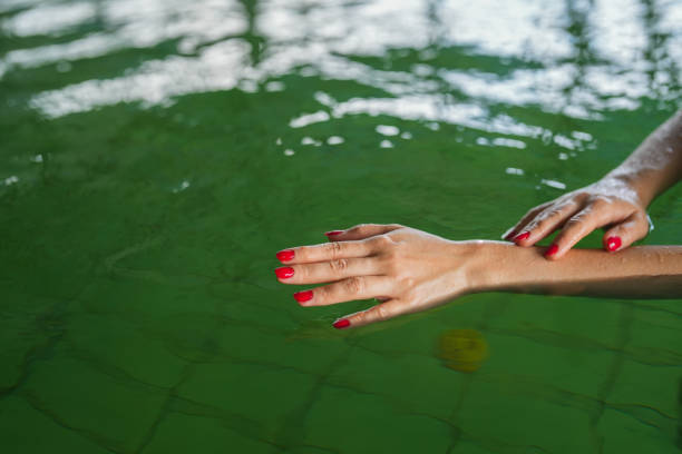 istock hands with red nail polish in hot water pool 1819014200