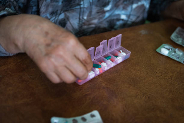 istock person organizing his medicines in a pill box at home. Selective focus on pill box. 1819015497