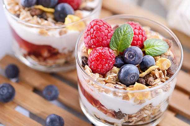 parfait, salsa di fragole con yogurt, muesli e frutta fresca - biscuit red blue macro foto e immagini stock