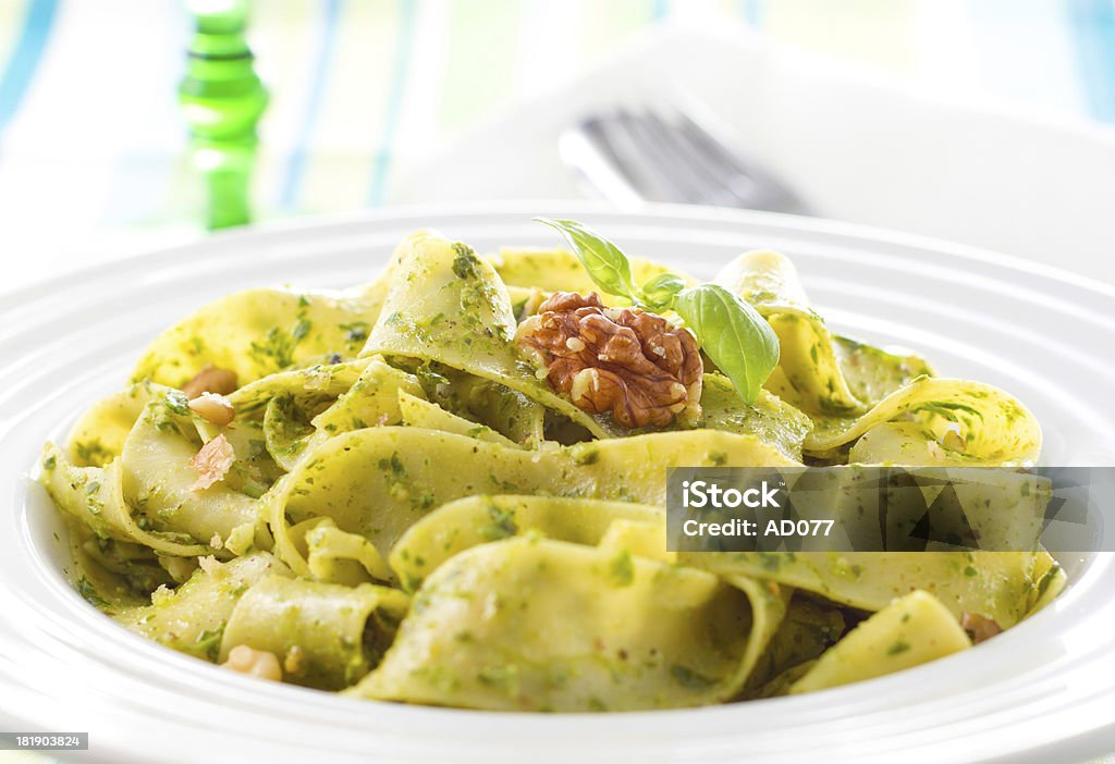 Tagliatelle pasta with pesto Tagliatelle pasta with pesto and walnuts on white plate Tagliatelle Stock Photo