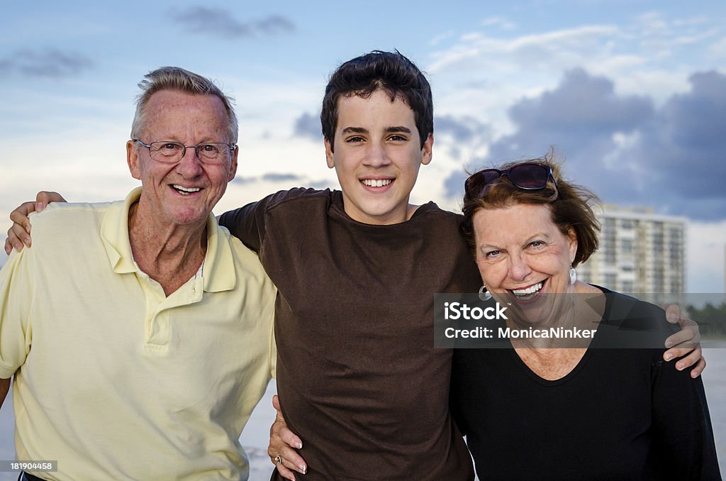 Grandparents and grandson Grandfather, grandmother and grandson posing happily together 14-15 Years Stock Photo