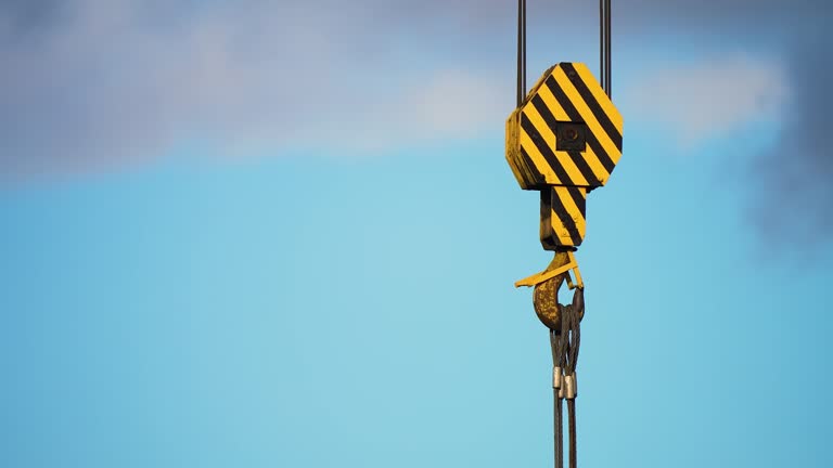 Close-up mobile crane hooks. Hooks on steel cable against blue sky. Left side Copy space for placing text