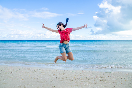 Teenage Girl jumping in front of Varadero beach during day