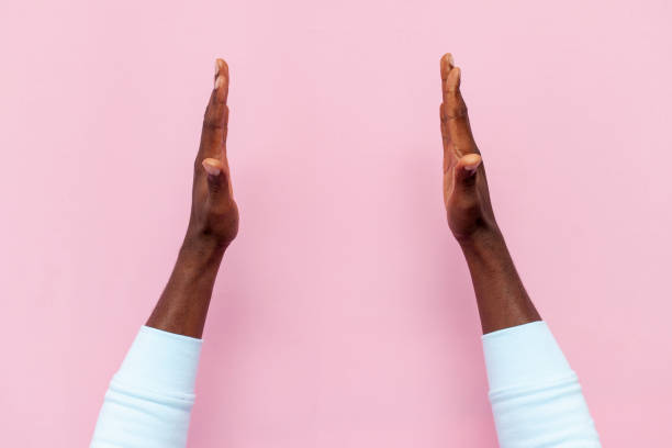 istock african male hands holding empty space on pink isolated background, hands show the size and advertise copy space 1819076720