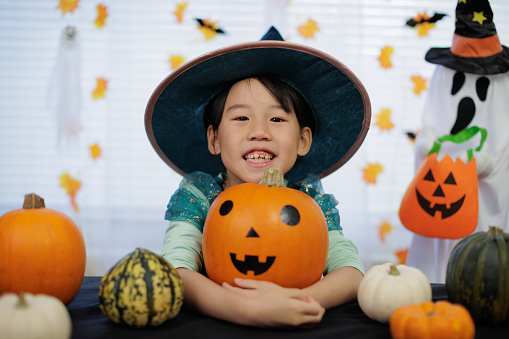 young Asian girl with witch costume was enjoying Halloween party  at home