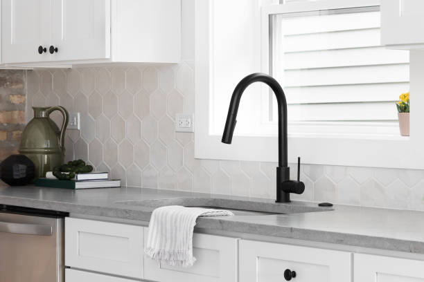istock A kitchen sink detail with a marble countertop and hexagon tiled backsplash. 1819169858