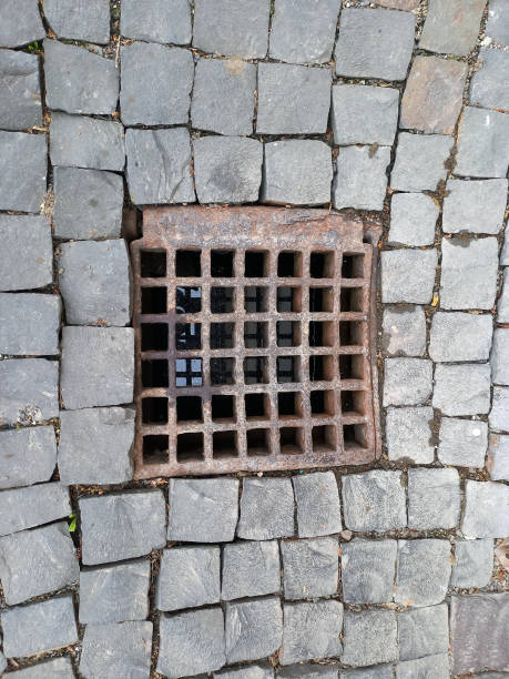 istock A sewer drain with an iron grate on a stone cobblestone sidewalk 1819180601