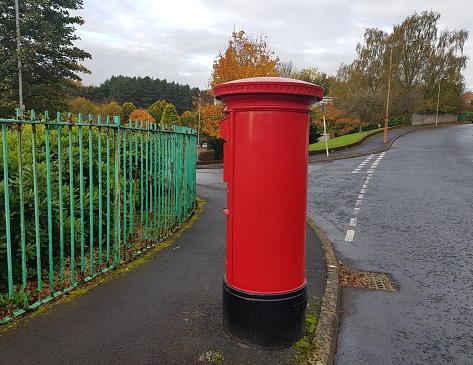 A red mail box or post box at a street of Glasgow Scotland England UK