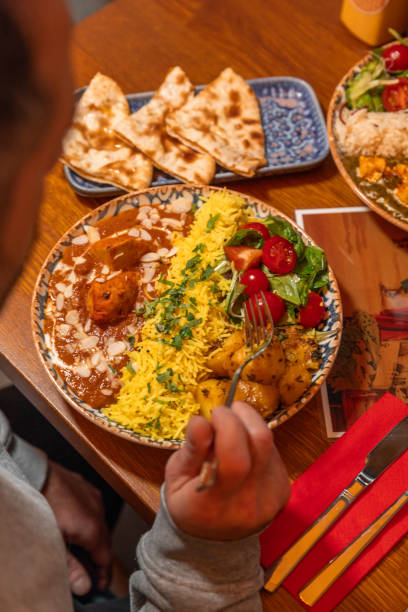 istock Eating Butter Chicken dish with saffron rice on plate at Indian Restaurant 1819242031