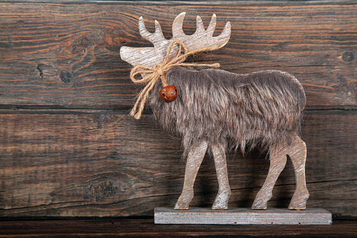 Christmas decoration deer in front of rustic wooden background