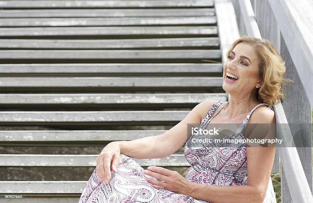 座っている美しい女性ステアズと笑う屋外 - 中年の女性のロイヤリティフリーストックフォト