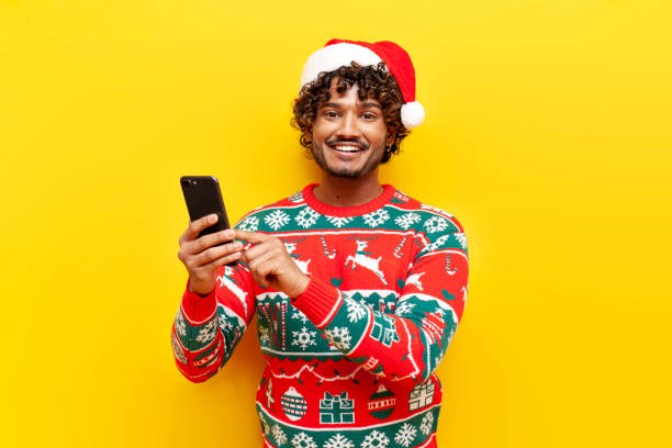 istock young curly hindu man in new year clothes using smartphone on yellow isolated background 1819293701