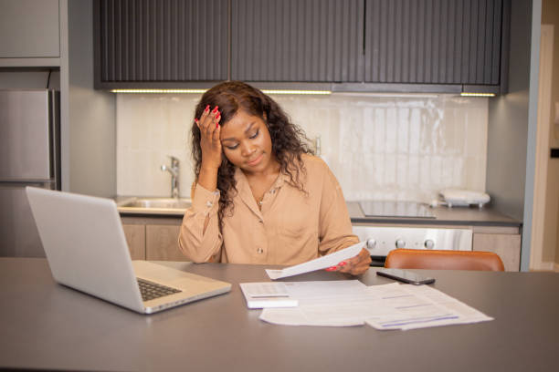 istock Young woman using calculator while going through bills and home finances 1819306276