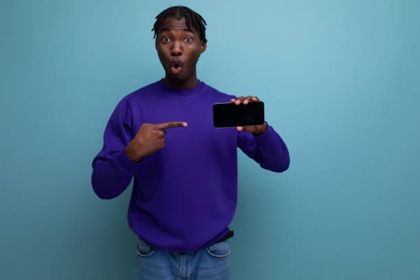 istock surprised joyful african young man with dreadlocks holding smartphone 1819308129
