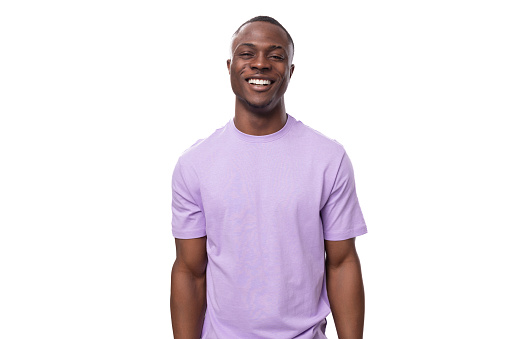 young positive american man in a lilac t-shirt is inspired by an idea and success on a white background.
