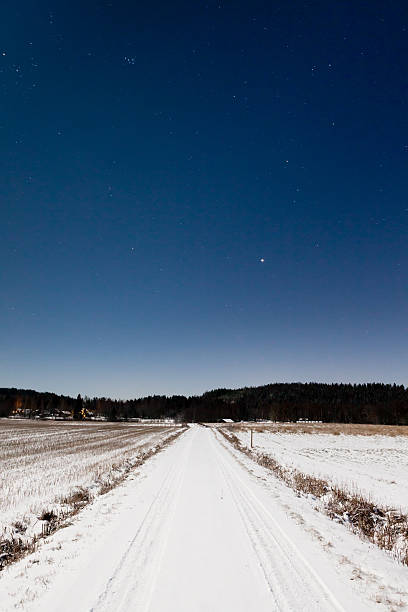 istock Long snowy road and clear starry sky in moon light 181933371