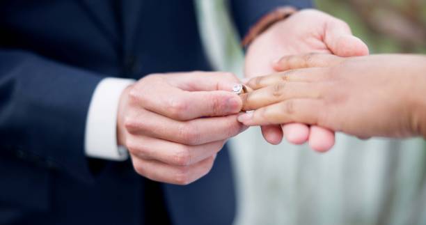 istock Couple, hands and ring for marriage, commitment or wedding in ceremony, love or support together. Closeup of people getting married, vows or accessory for symbol of bond, relationship or partnership 1819369145