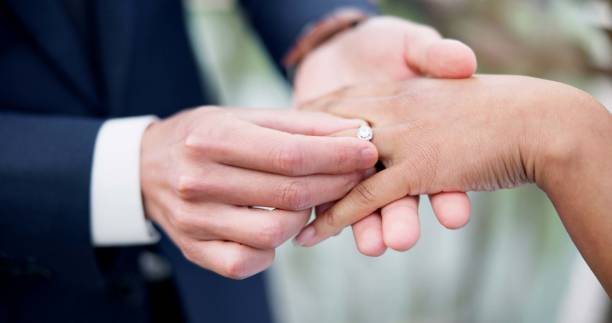 istock Couple, hands and ring for marriage, love or wedding in ceremony, commitment or support together. Closeup of people getting married, vows or accessory for symbol of bond, relationship or partnership 1819369149