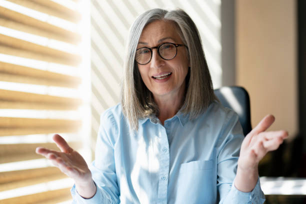 istock Gray haired businesswoman talking, explaining something having video call. Video conference 1819384092