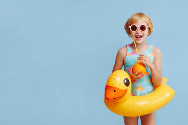 istock Child with inflatable duck ring on blue background with copy space. 1819466332