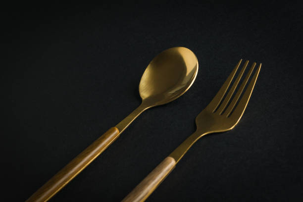 istock Gold-plated spoon and fork on a black background. 1819504697