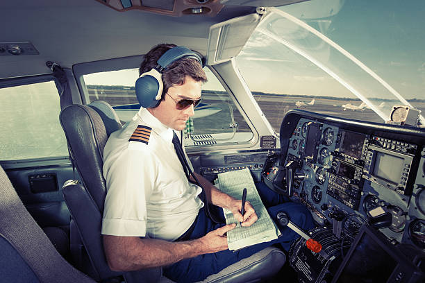 istock Pilot of Small Commuter Aircraft Writing in Log Book 181954155
