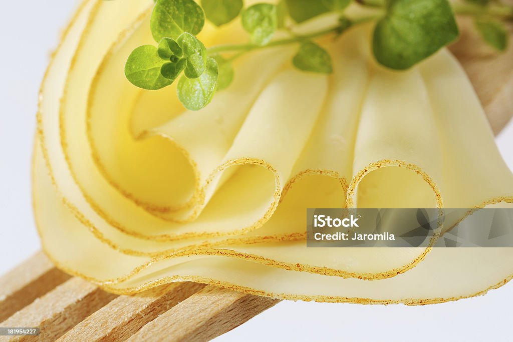 Rodajas de queso en un tenedor de madera - Foto de stock de Amarillo - Color libre de derechos