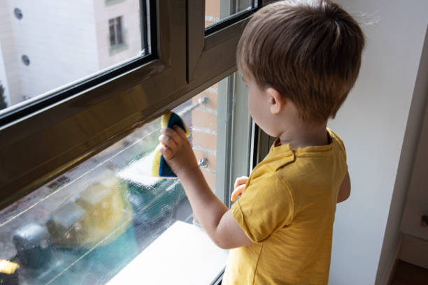 istock Little boy is washing the window with a sponge 1819546798