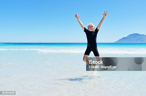 Foto de Energia 10 Anos Velho Menino Pulando De Alegria Na Praia e mais fotos de stock de Criança