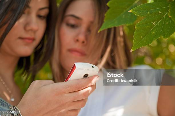 Due Giovani Donne Guardando I Loro Telefoni Cellulari - Fotografie stock e altre immagini di Abbigliamento casual