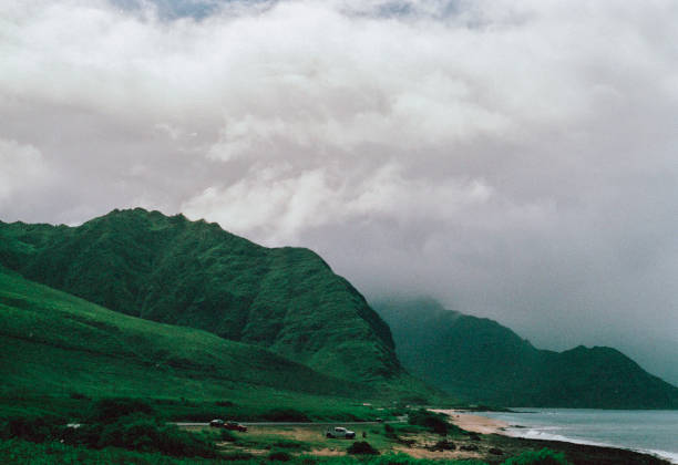 Mountains hug the Hawaii coastline on an overcast day. in Hawaiian Beaches, Hawaii, United States