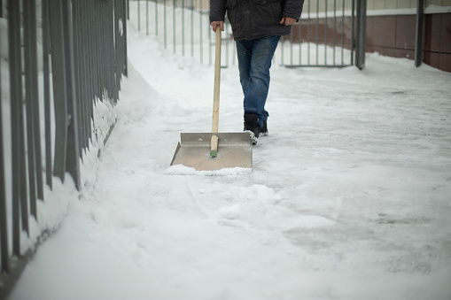 Snow removal on street. Shovel for track cleaning. Man cleans up yard. in Moscow, Moscow, Russia