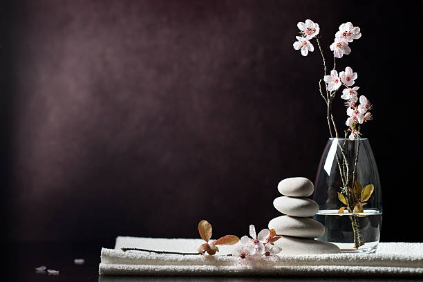 Black and white zen spa flower background "SEVERAL MORE IN THIS SERIES. Tranquil zen spa background concept, with white massage stones, cherry blossoms and towel.  Copy space.  Very high resolution, so you can crop if desired." alternative medicine photos stock pictures, royalty-free photos & images