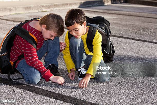 School Boys Kneeling On The Ground Playing Stock Photo - Download Image Now - Boys, Child, Kneeling