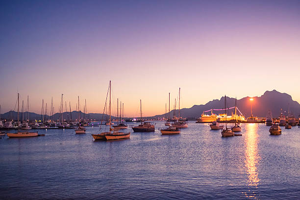 Collection of sailing ships in Porto Grande, Mindelo on the island of São Vicente: tourism is a growing source of income on the islands. The mountains behind,the island of Santo Antao.