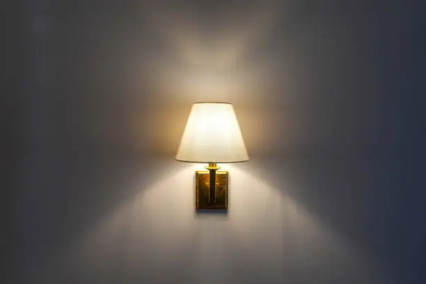 Warm glow of wall mounted lamp inside home