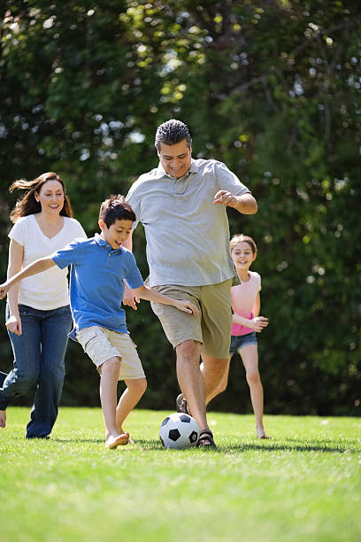 istock Family Playing Soccer In Park 181957068