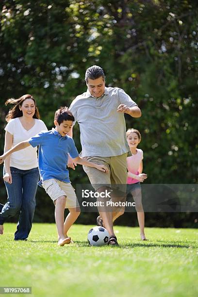 Família Jogando Futebol No Parque - Fotografias de stock e mais imagens de Família - Família, Futebol, Brincar