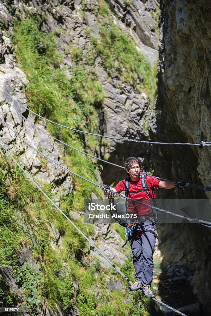 Alpinista em uma ponte de corda - Foto de stock de 30 Anos royalty-free