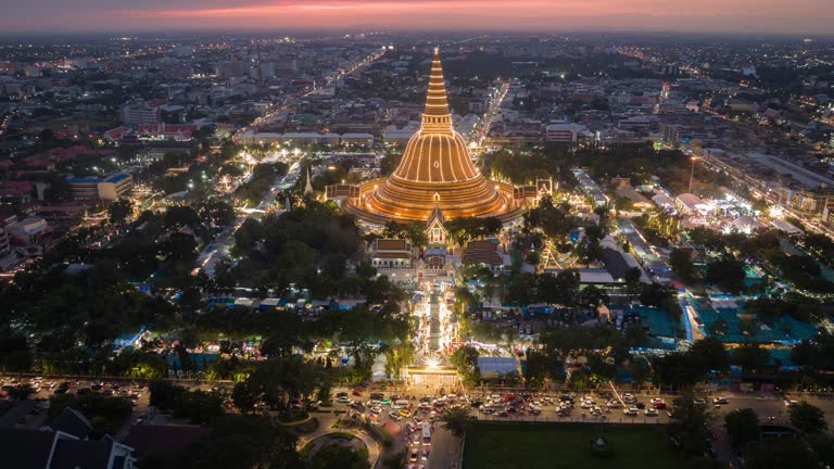 Hyper lapse or Drone lapse aerial view of Phra Pathommachedi at sunset during temple fair or night market festival, The great golden pagoda and world's tallest stupa in Nakhon Pathom province, western side of BangkokThailand