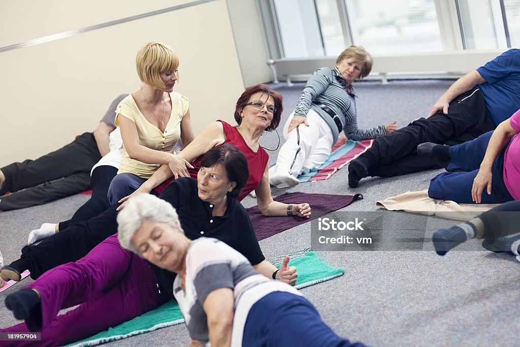 Les retraités faire des exercices d'étirement - Photo de 60-64 ans libre de droits