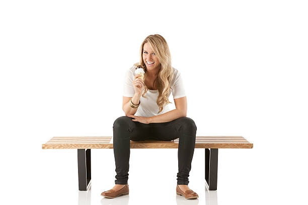 istock Woman sitting on a bench enjoying ice cream 181958274