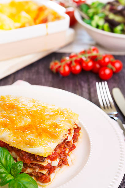 istock Homemade lasagna and green salad on a brightly lit table 181958698