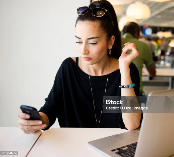 Foto de Mulher Caucasiana No Telefone Em Um Restaurante e mais fotos de stock de Adulto - Adulto, Café - Casa de comes e bebes, Computador