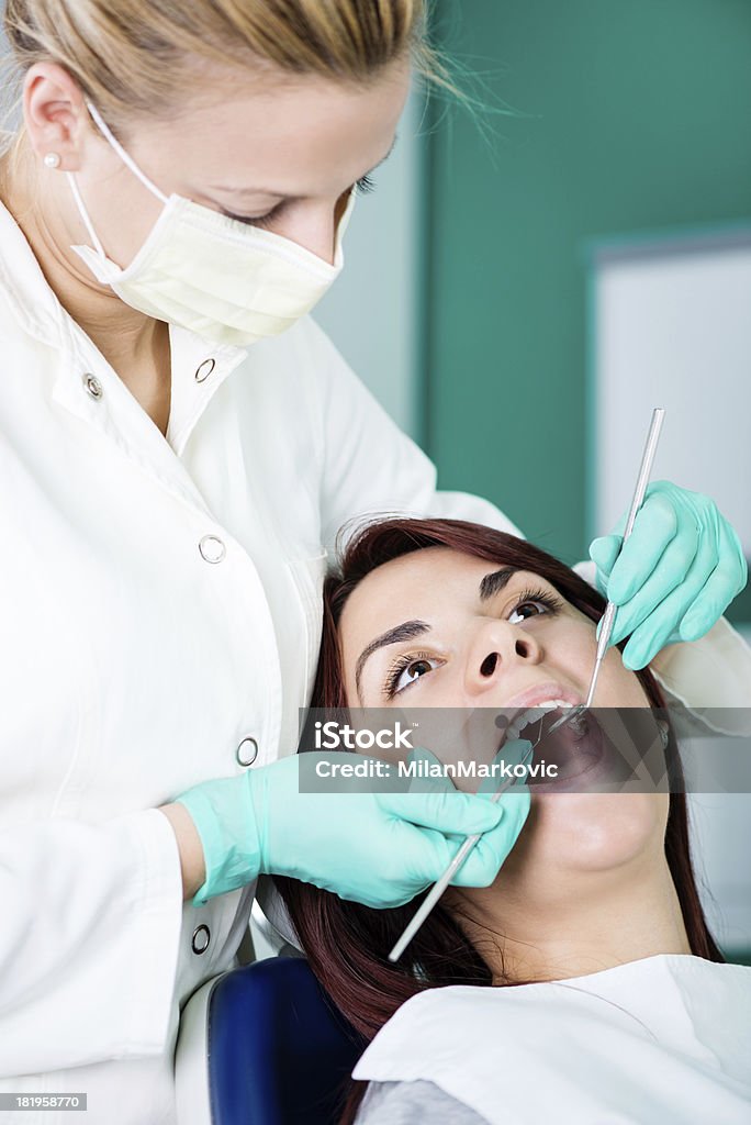 Dental inspection Young female dentist checking dental hygiene on patient in the office. Adult Stock Photo