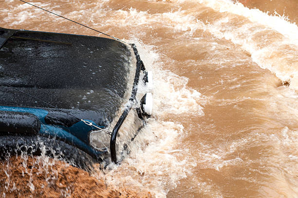 Flooded car. Jeep being driven in a flash flood. all weather running track stock pictures, royalty-free photos & images