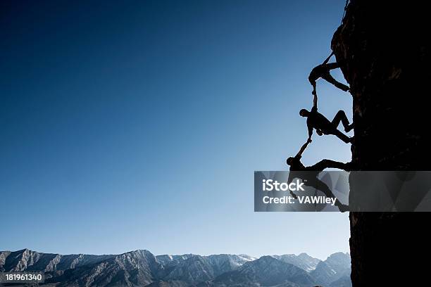 Foto de Silhueta De Três Alpinistas Na Lateral De Um Penhasco e mais fotos de stock de Força