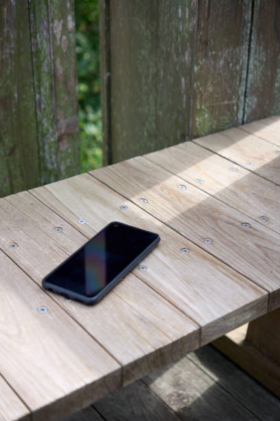 istock Cell phone placed on a wooden bench outdoors 1819615841