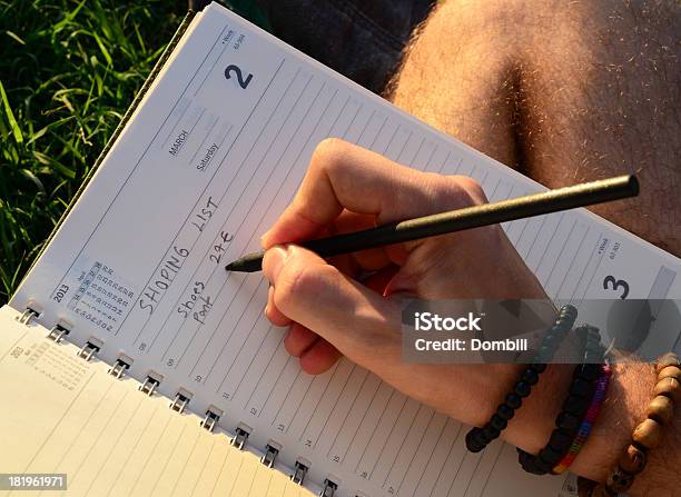 Young Man Writing On The Grass Stock Photo - Download Image Now - Book, Bracelet, Correspondence